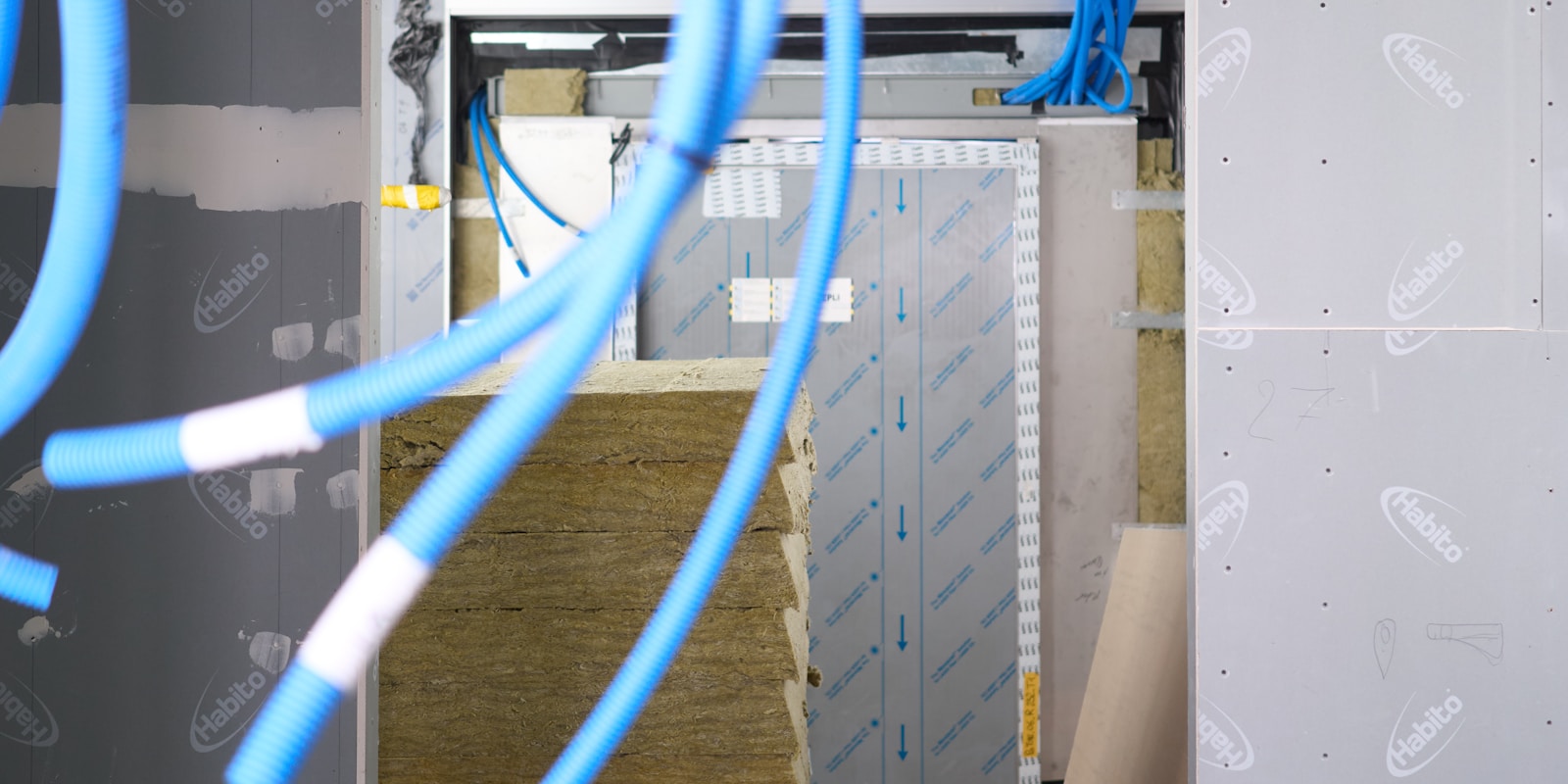 A room featuring blue wires running along the wall, highlighting an industrial or technical environment.