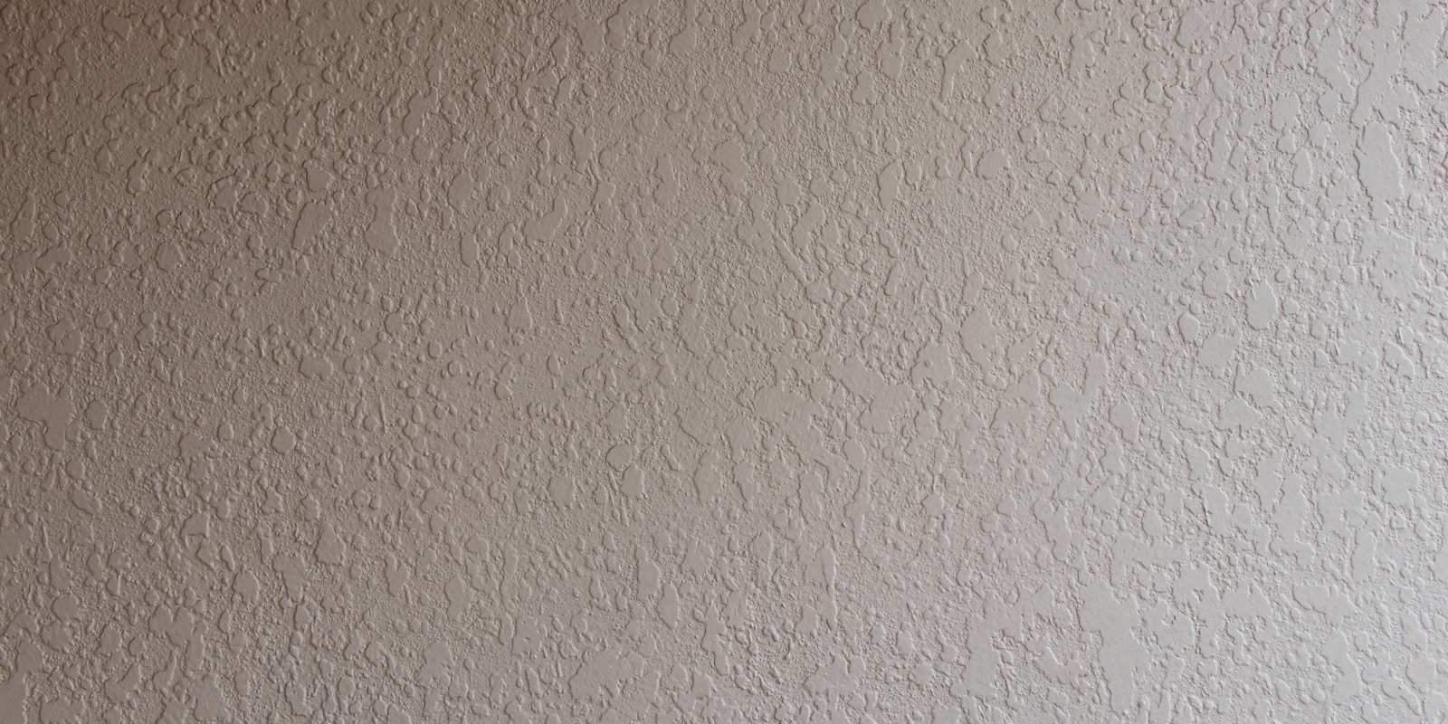 A white wall and ceiling illuminated by a bright white light, creating a clean and minimalistic interior space.