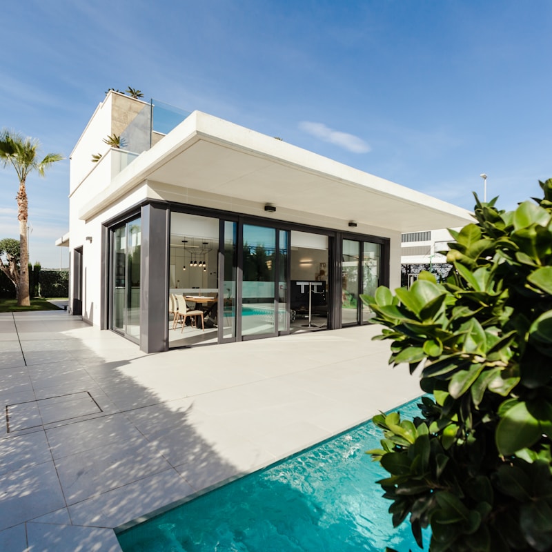 A modern home featuring a white exterior and contrasting black shutters.