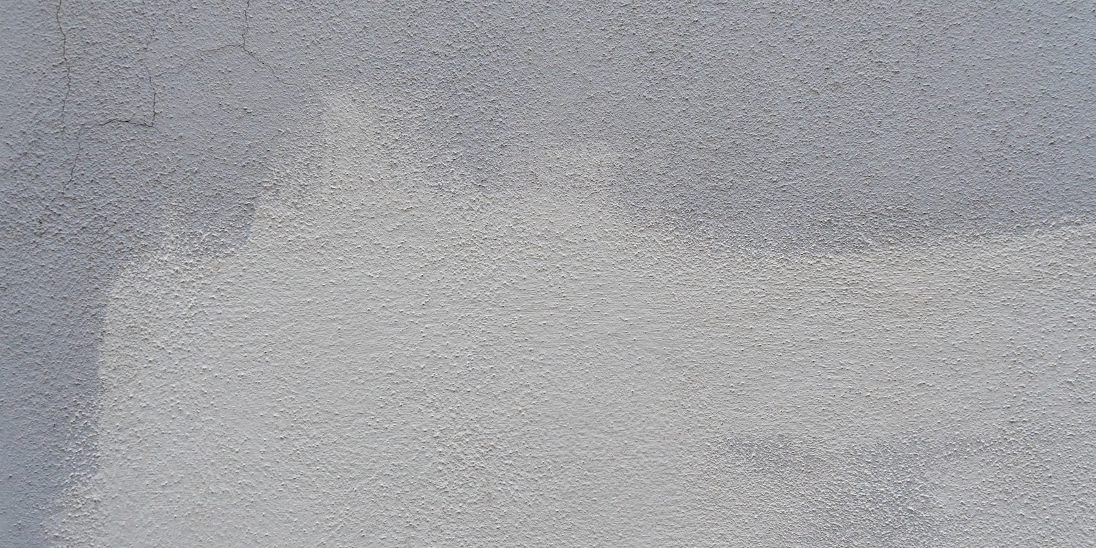 A white wall featuring a noticeable paint stain, adding a splash of color to the otherwise plain surface.