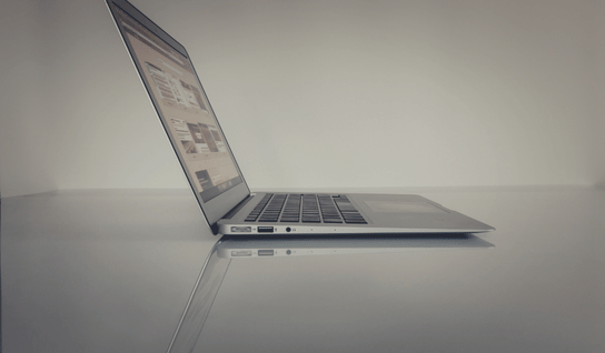Collection of four insulated travel bottles on wooden shelf.