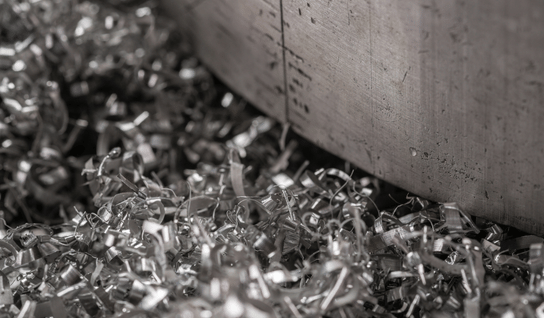 Desk with leather desk pad, walnut desk organizer, wireless keyboard and mouse, and porcelain mug.