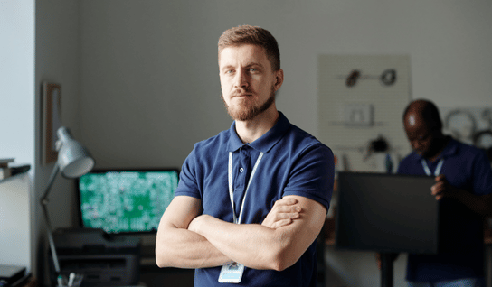 Desk with leather desk pad, walnut desk organizer, wireless keyboard and mouse, and porcelain mug.