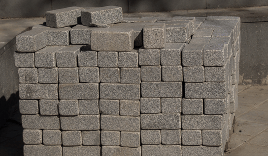 Desk with leather desk pad, walnut desk organizer, wireless keyboard and mouse, and porcelain mug.