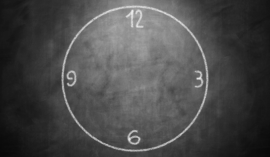 Wood table with porcelain mug, leather journal, brass pen, leather key ring, and a houseplant.