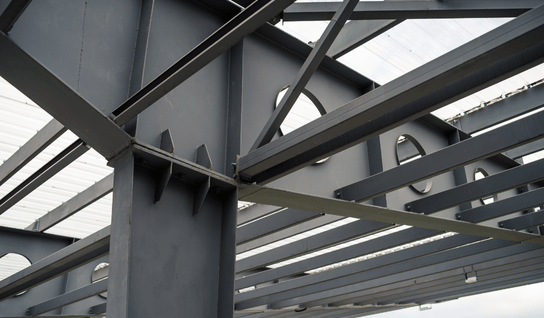 Wood table with porcelain mug, leather journal, brass pen, leather key ring, and a houseplant.