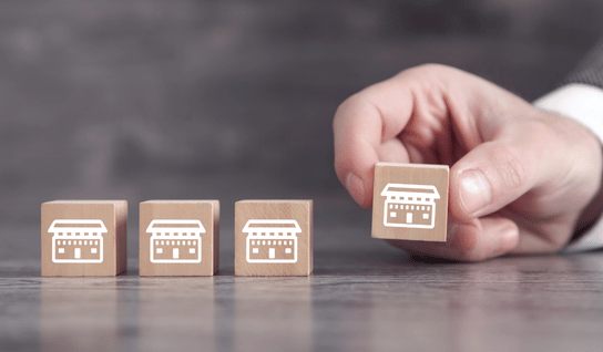 Collection of four insulated travel bottles on wooden shelf.