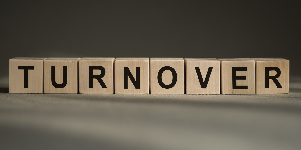 Desk with leather desk pad, walnut desk organizer, wireless keyboard and mouse, and porcelain mug.