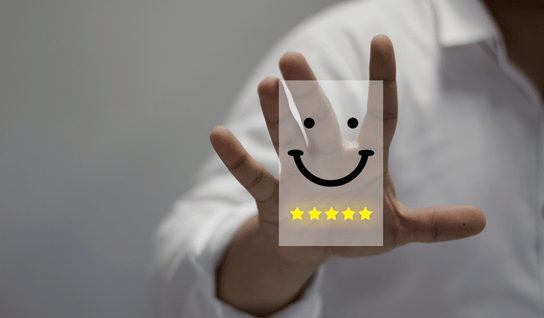 Desk with leather desk pad, walnut desk organizer, wireless keyboard and mouse, and porcelain mug.