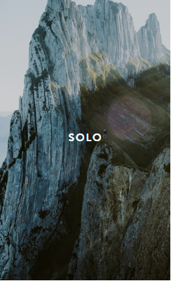 Tall slender porcelain bottle with natural clay textured body and cork stopper.