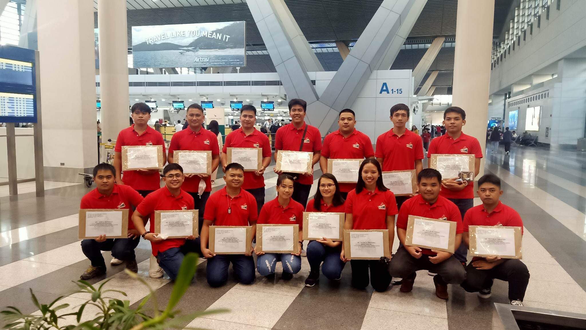 Wood table with porcelain mug, leather journal, brass pen, leather key ring, and a houseplant.