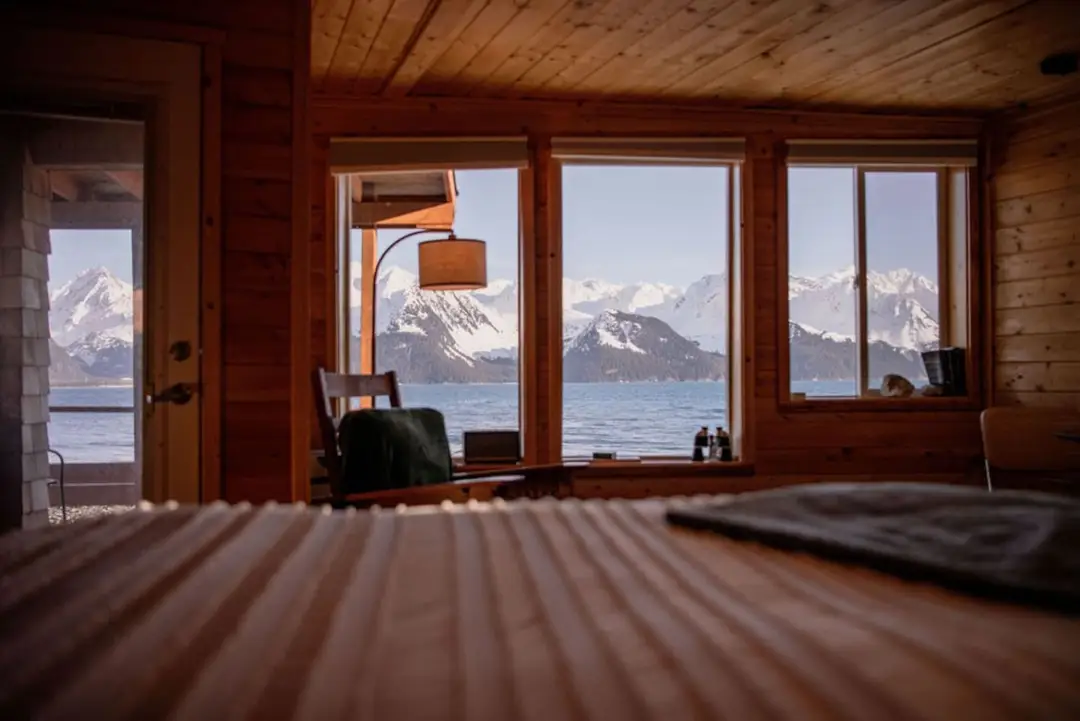Collection of four insulated travel bottles on wooden shelf.