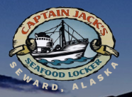 Wood table with porcelain mug, leather journal, brass pen, leather key ring, and a houseplant.
