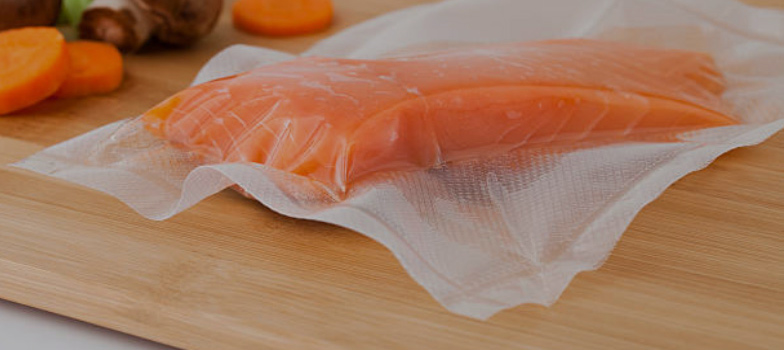 Desk with leather desk pad, walnut desk organizer, wireless keyboard and mouse, and porcelain mug.