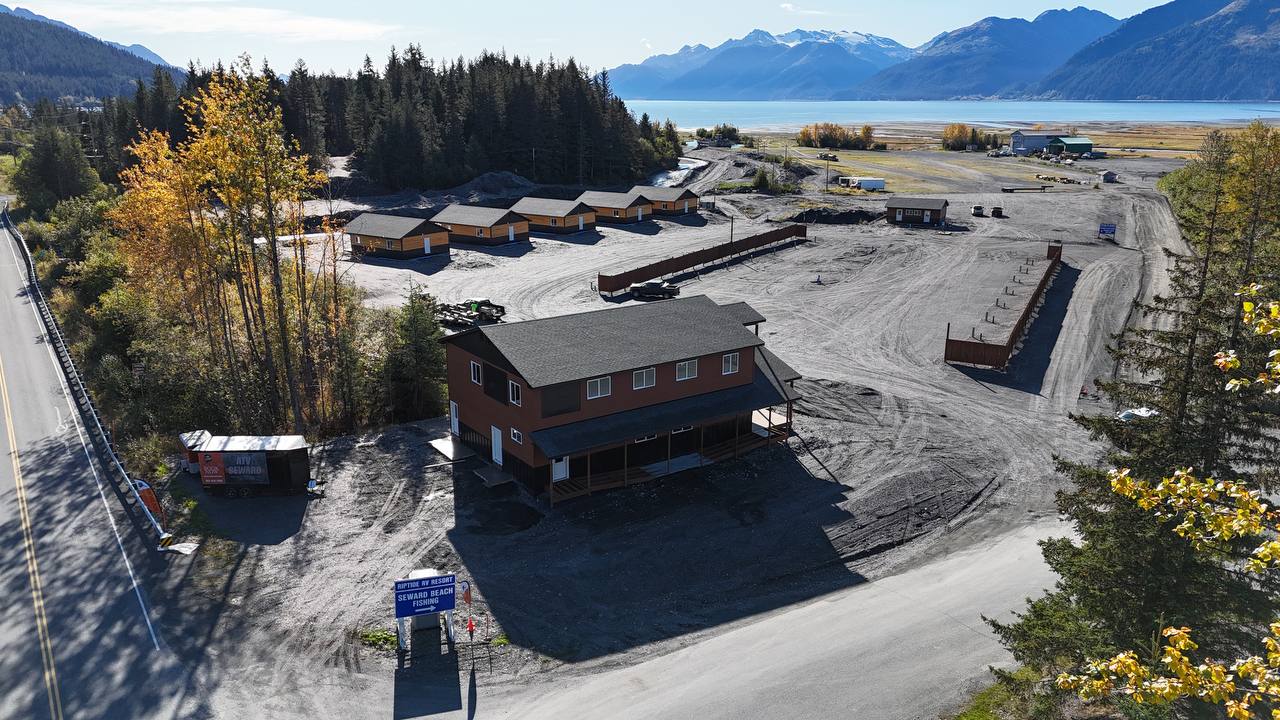 Desk with leather desk pad, walnut desk organizer, wireless keyboard and mouse, and porcelain mug.
