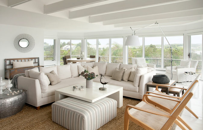 Bright coastal living room with white sofas and large windows, deep cleaned and refreshed