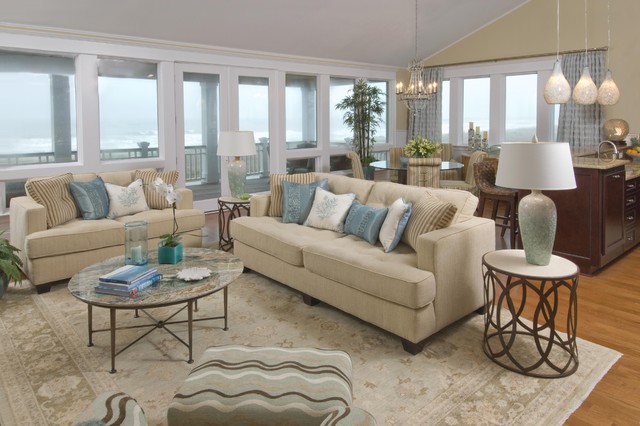 Bright coastal vacation rental living room with sofas and ocean-view windows, cleaned and staged before guest check-in