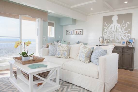 Coastal vacation home living room with white sofas and ocean views, cleaned and staged for guests