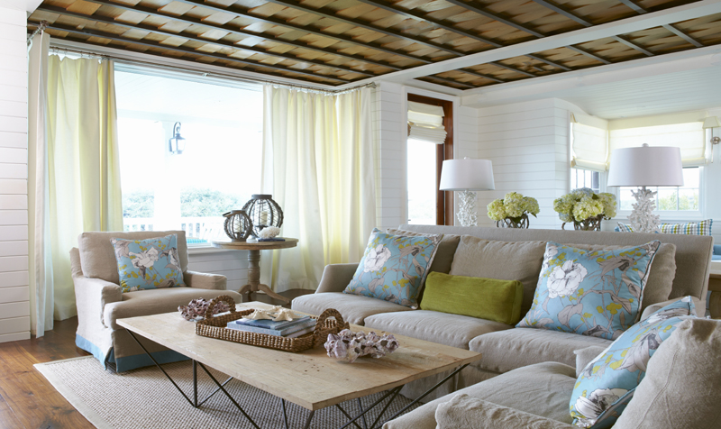 Coastal vacation home living room with a sofa, coffee table, and beach-inspired decor staged for arriving guests