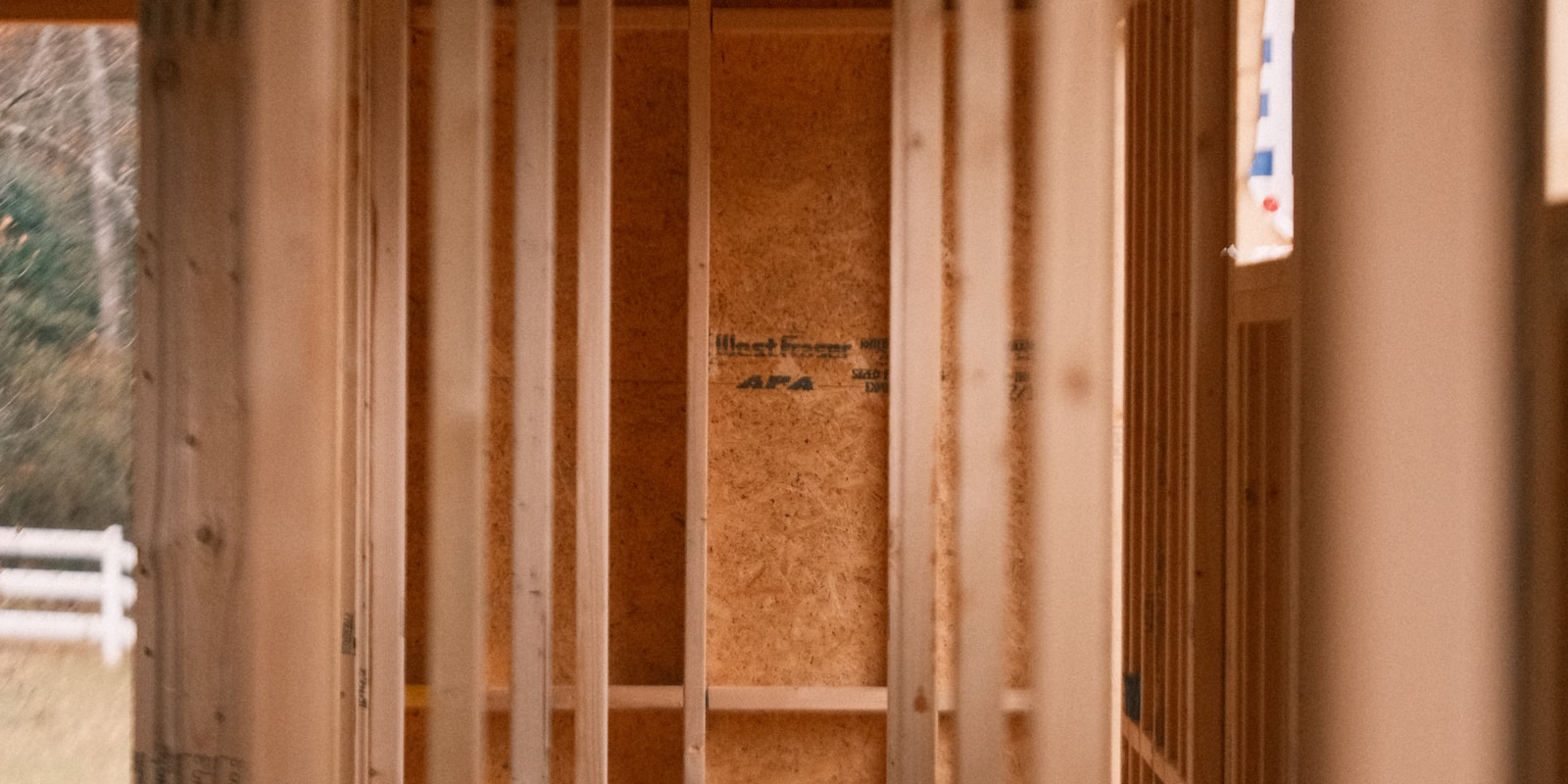 A wooden frame is under construction inside a house, showcasing the building process of the interior structure.