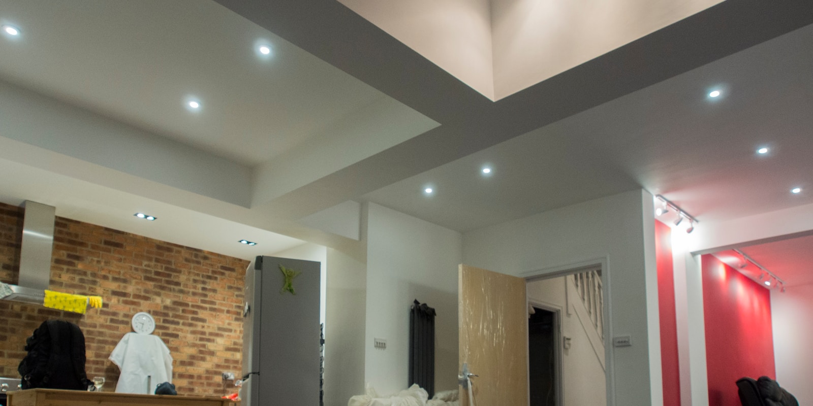 A room featuring a red brick wall and a white ceiling, creating a warm and inviting atmosphere.