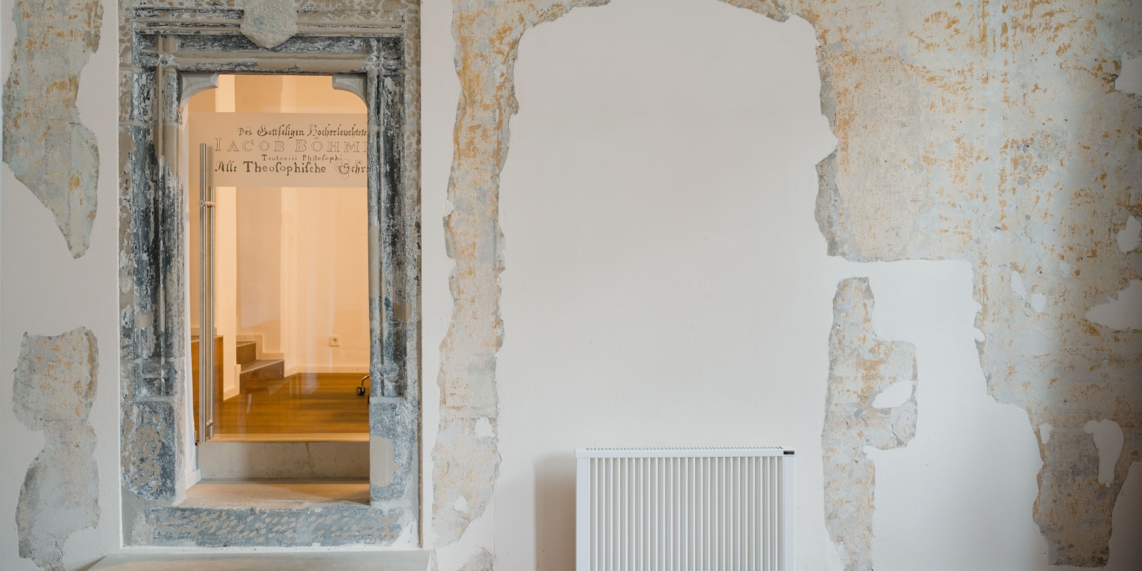 A room featuring a radiator against the wall and a closed door on the opposite side.