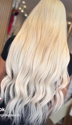 Long icy blonde hair extensions with soft waves by Fly Girls Ipswich