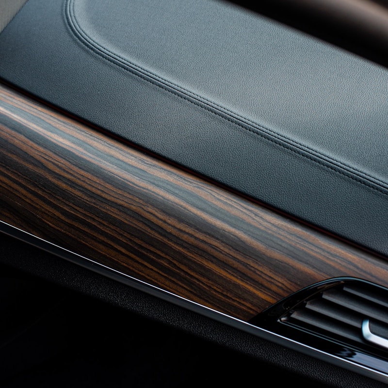 Interior of a car featuring elegant wood trim on the dashboard and door panels, showcasing a luxurious design.