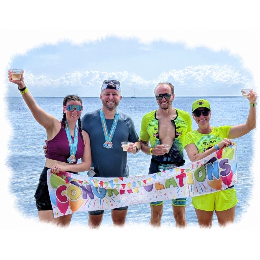 SLAP athletes celebrating with a congratulations banner at the beach