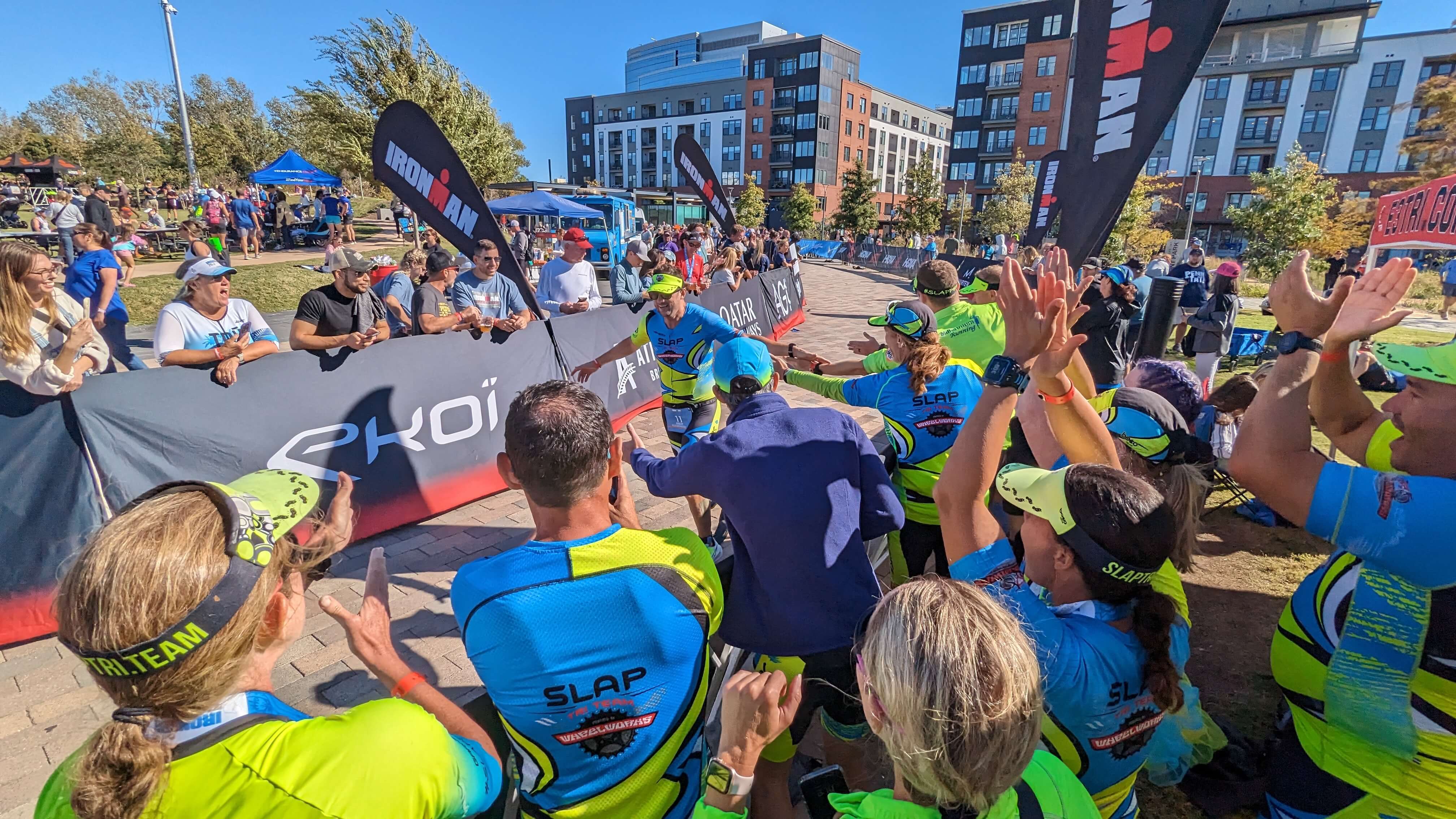 SLAP Tri Team athletes cheering at an Ironman finish line