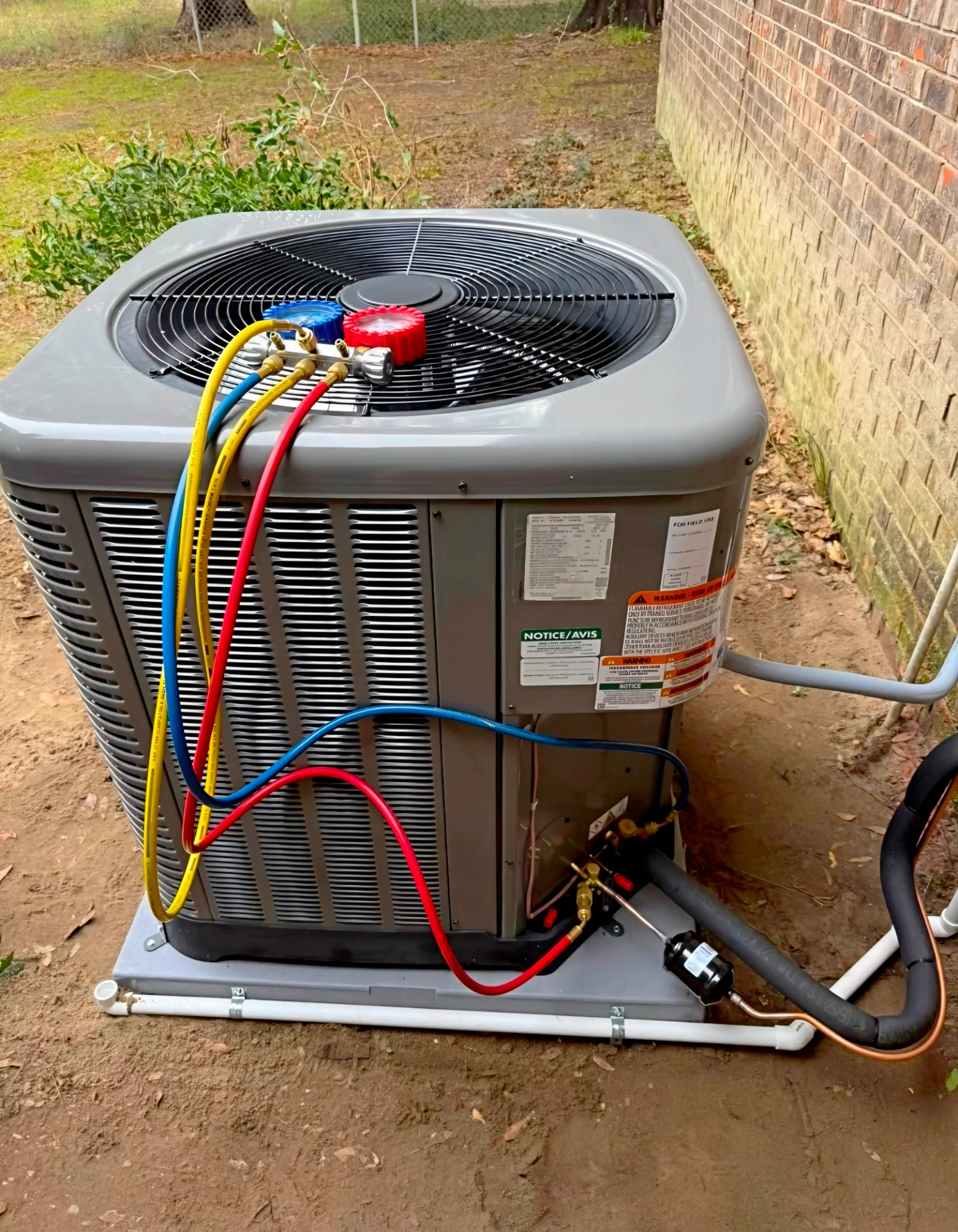 Outdoor air conditioning unit with manifold gauges connected during service
