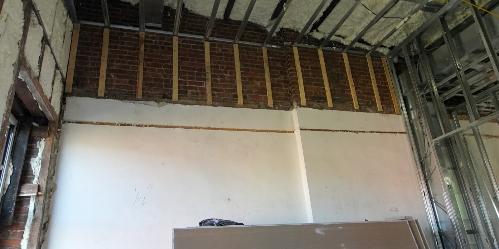 A room featuring a combination of a brick wall and drywall, showcasing a blend of textures and materials.