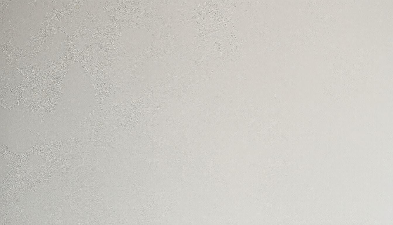 A plain white wall meets a white ceiling, creating a seamless and minimalist interior space.