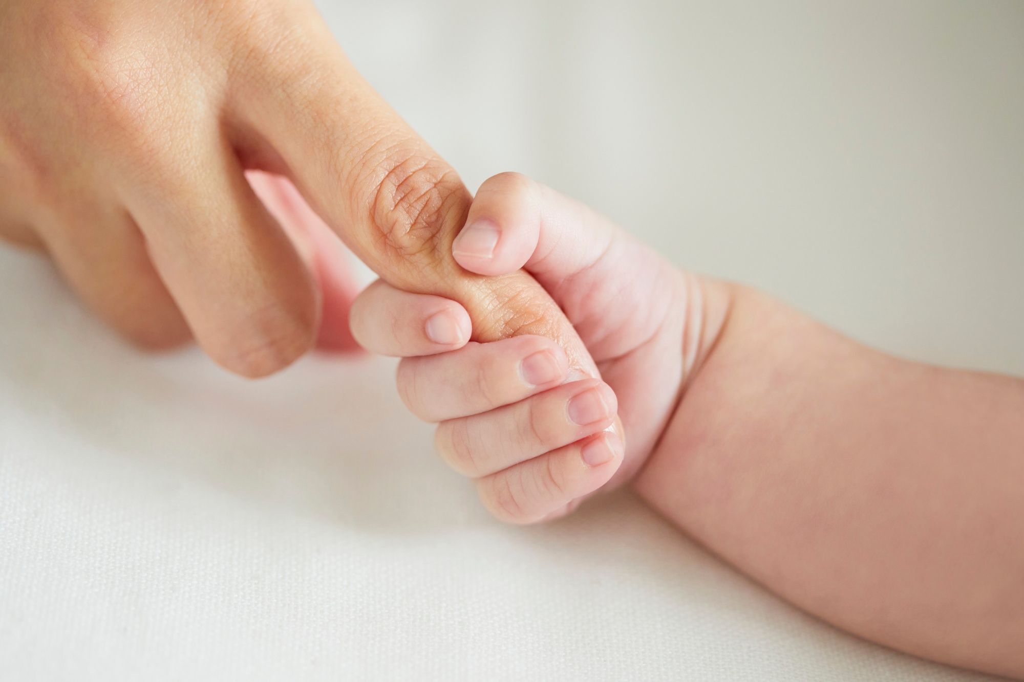 Baby hält Hand der Mutter fest