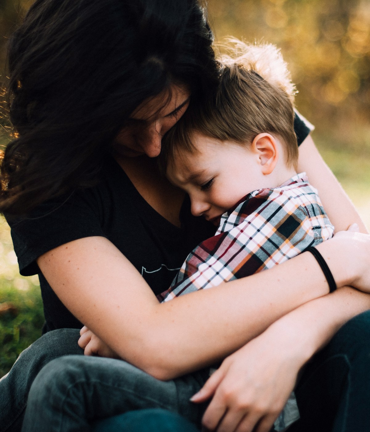 Mutter hält weinendes Kind im Arm und gibt Trost